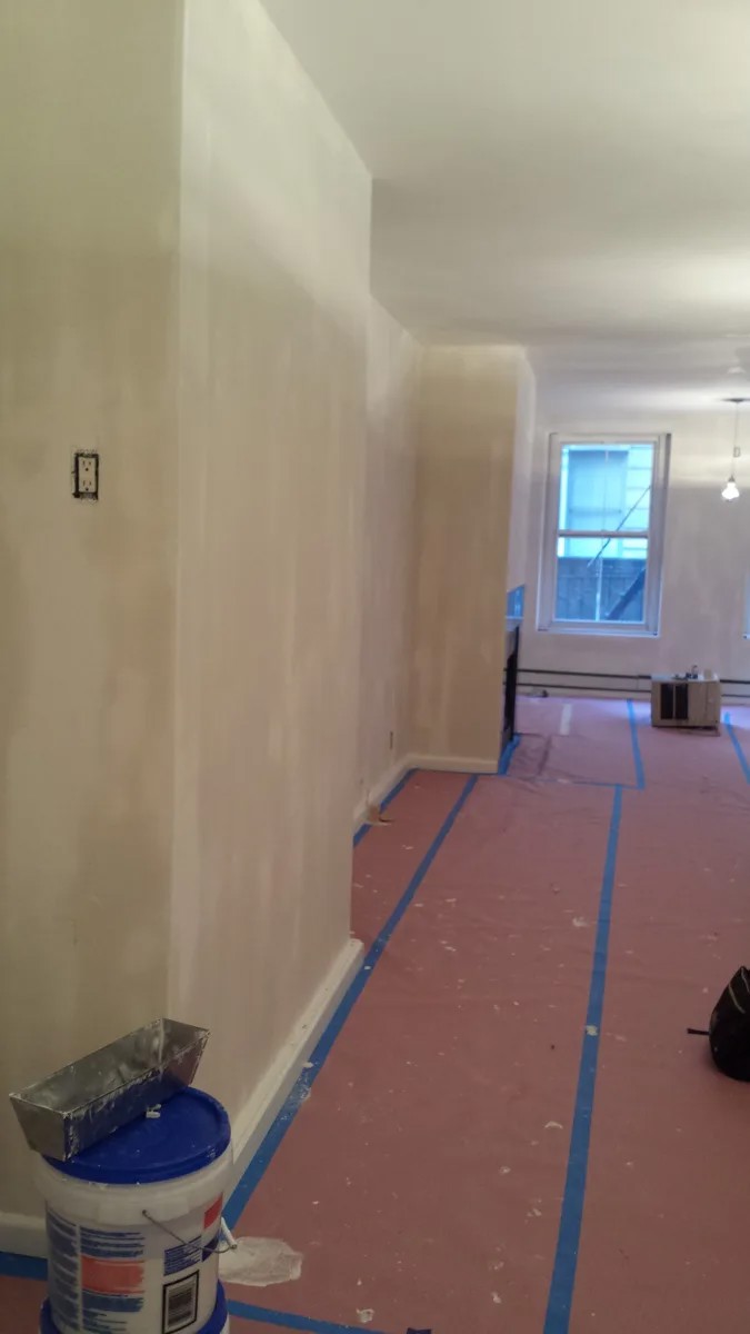 Wall preparation and tools during Corniel painting work in a Manhattan loft.