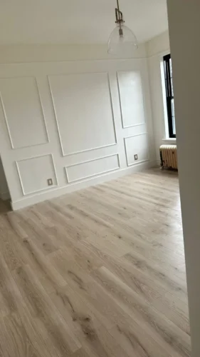 White picture-frame wall moldings and light-toned flooring during a Corniel apartment renovation.
